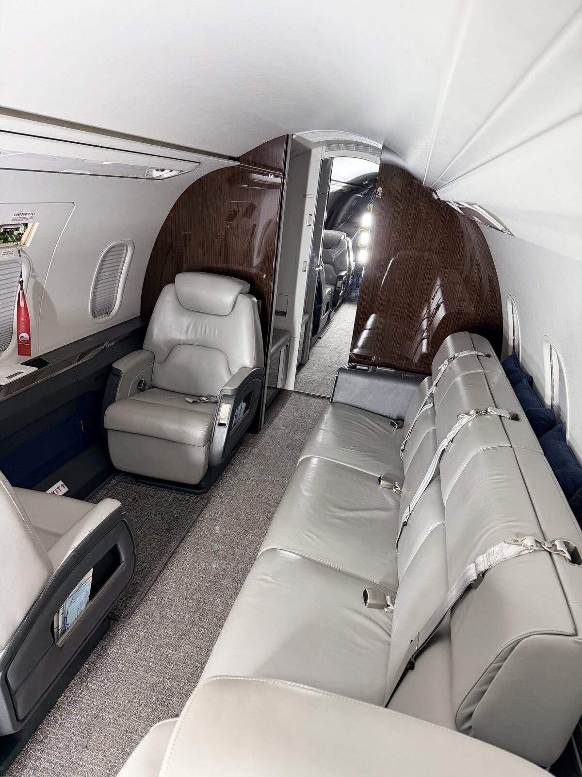 After: Challenger 350 forward cabin reset showing club seats, couch, wood veneer, and clean carpet