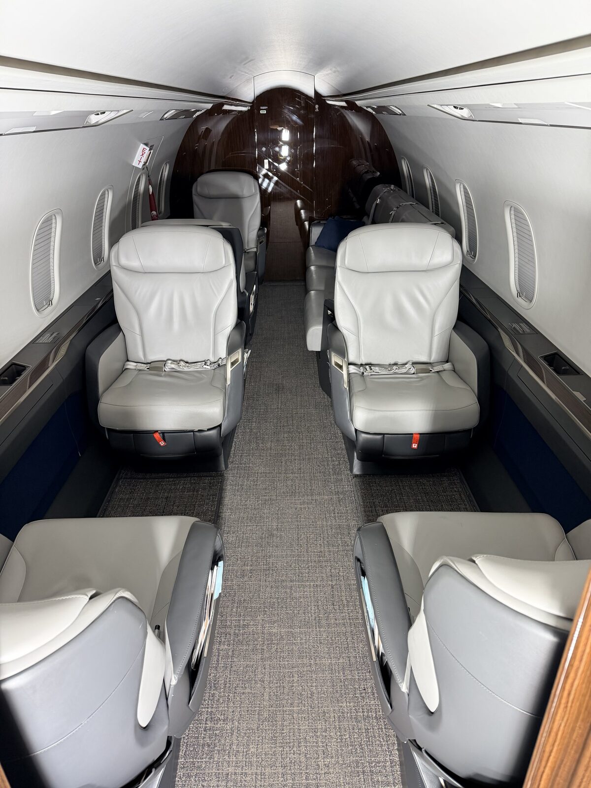 After: Challenger 350 full cabin view showing reset club seats, clean carpet, and polished wood veneer