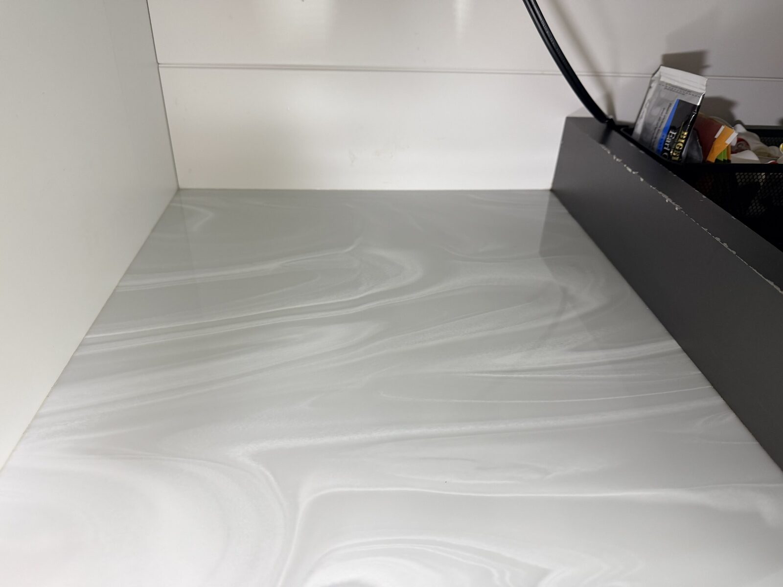After: Challenger 350 galley counter reset with clean marble-pattern surface and organized provisioning