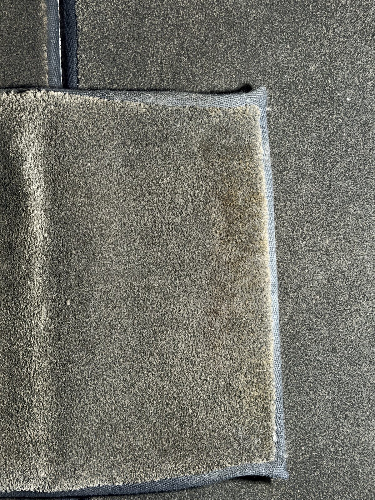 Before: removable carpet panel with visible spot stains