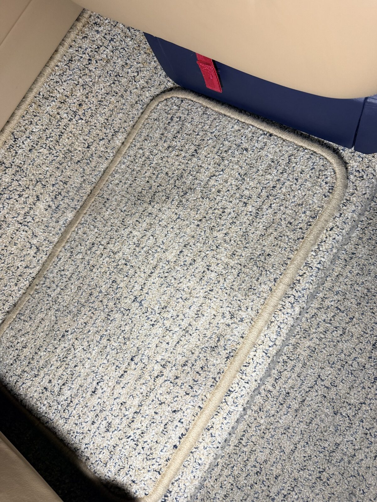 Before: removable carpet panel with use-related buildup in Phenom 300 cabin