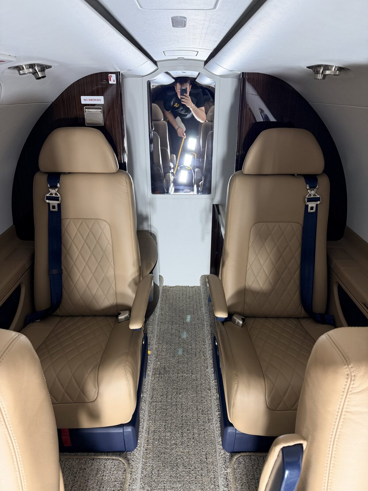 After: Phenom 300 compact cabin reset with clean carpet, conditioned leather seating, and organized presentation