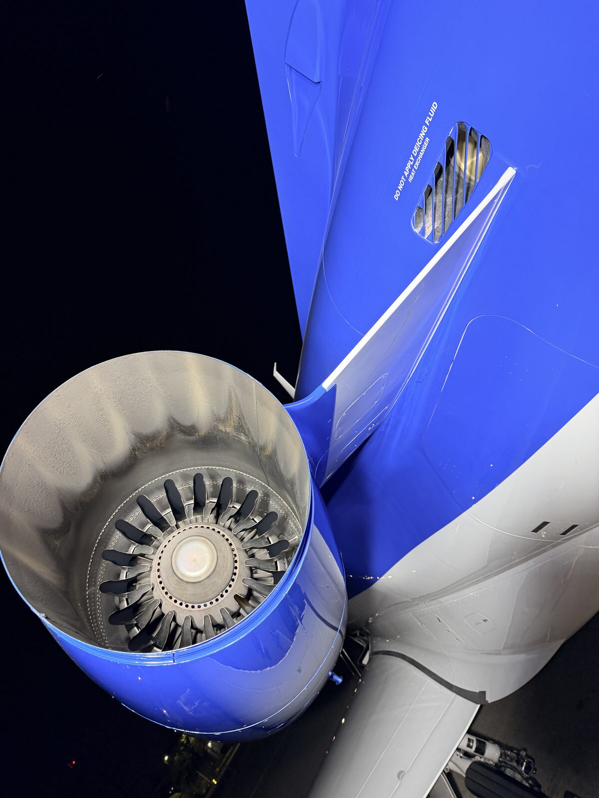 Phenom 300 engine nacelle closeup showing fan blades and blue cowling after detail