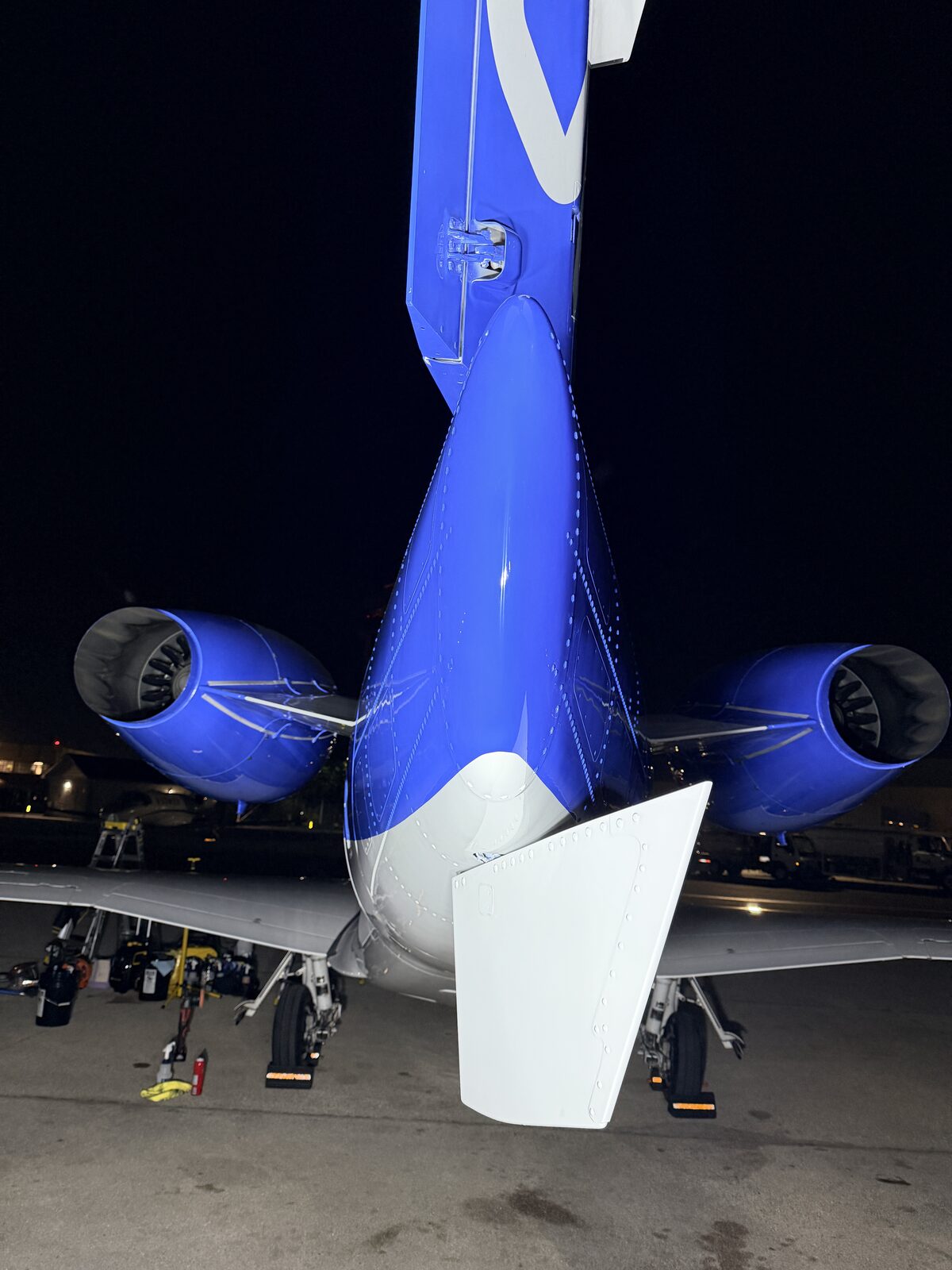 Phenom 300 tail section and dual engines rear view on the ramp at night after exterior detail