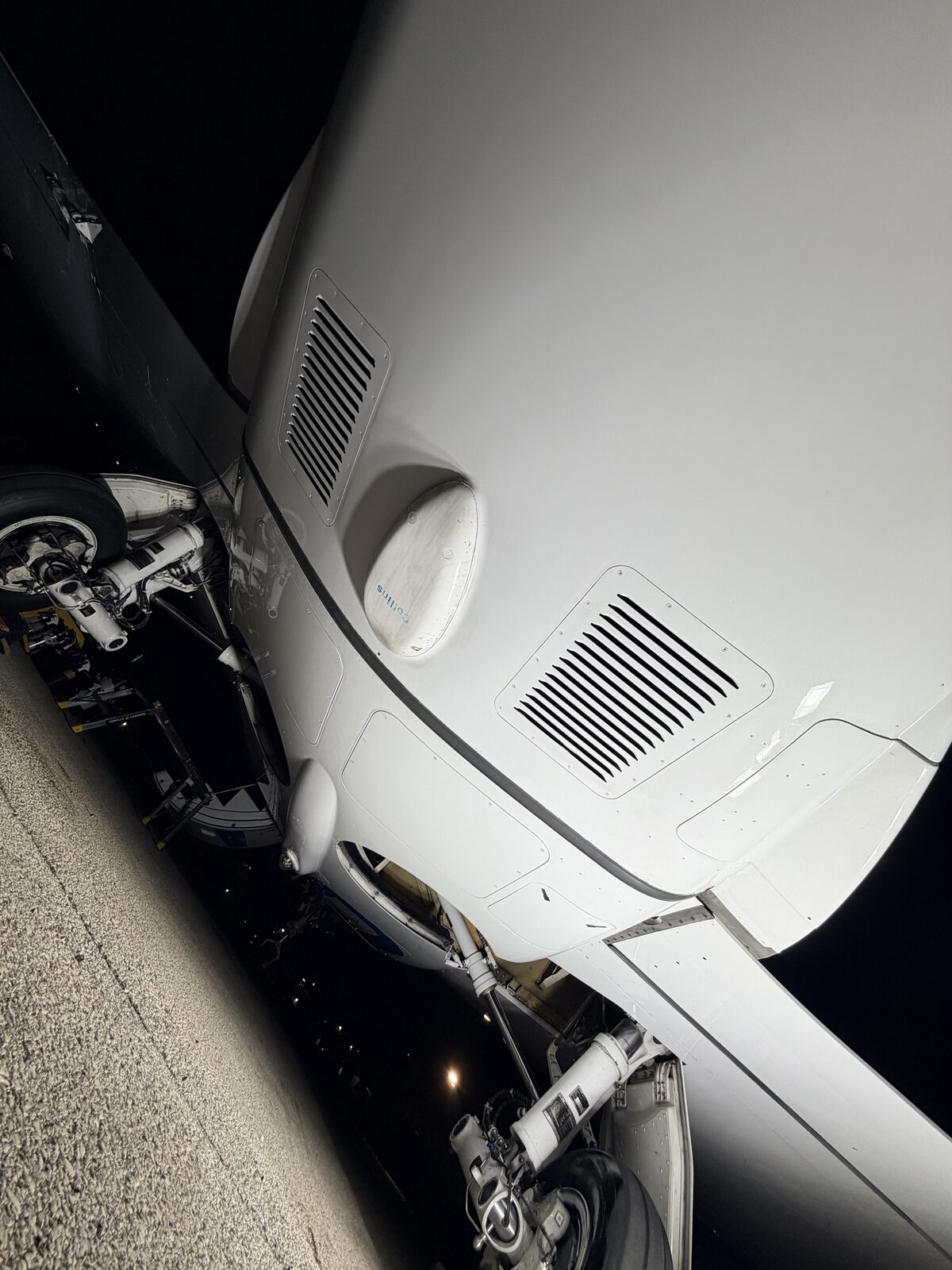 Phenom 300 underbelly and nose gear area showing vents and landing gear after decontamination