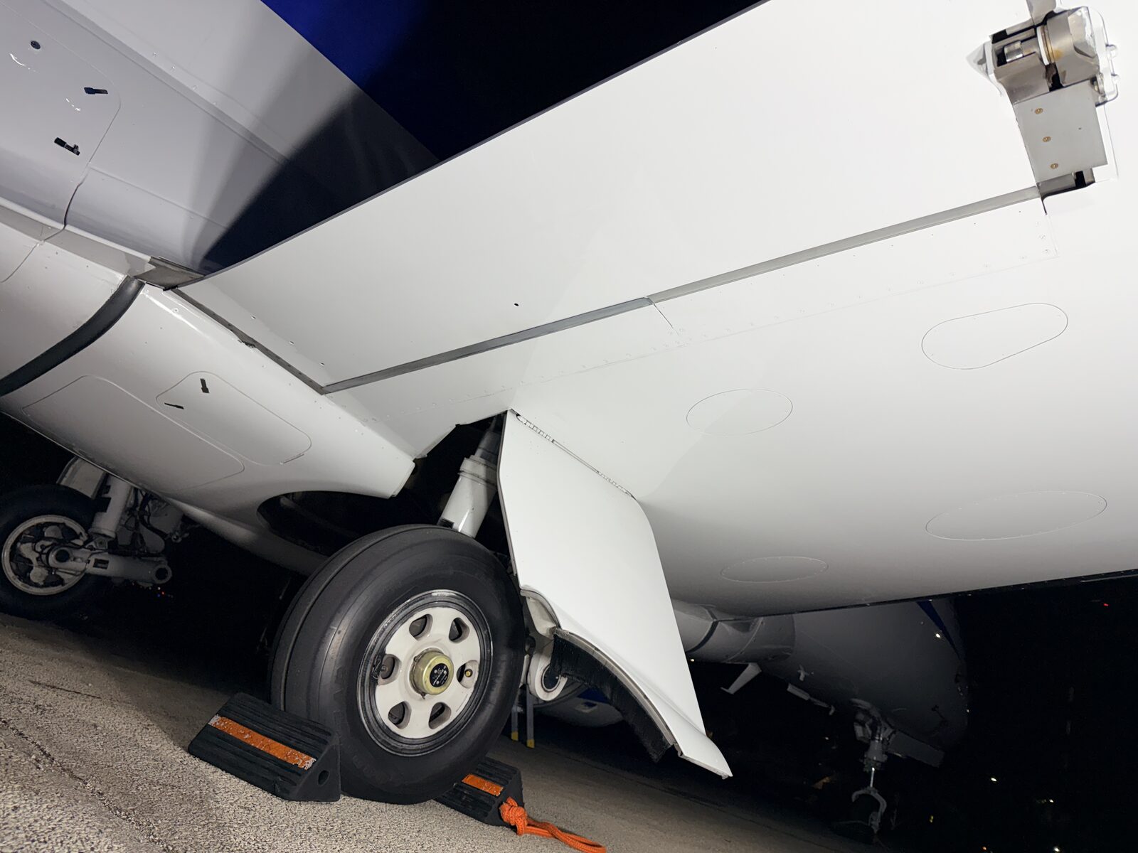Phenom 300 main landing gear and lower fuselage with wheel chocks after exterior cleaning