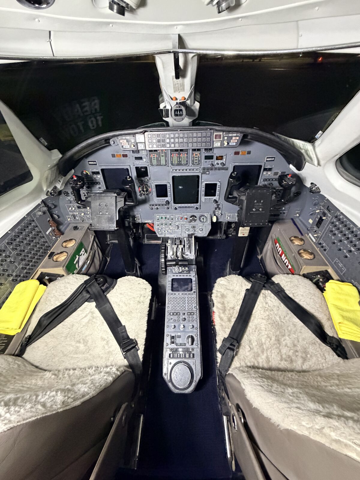 Cessna Citation Excel cockpit full view showing analog instrument panels, sheepskin seats, and overhead switches after detailing