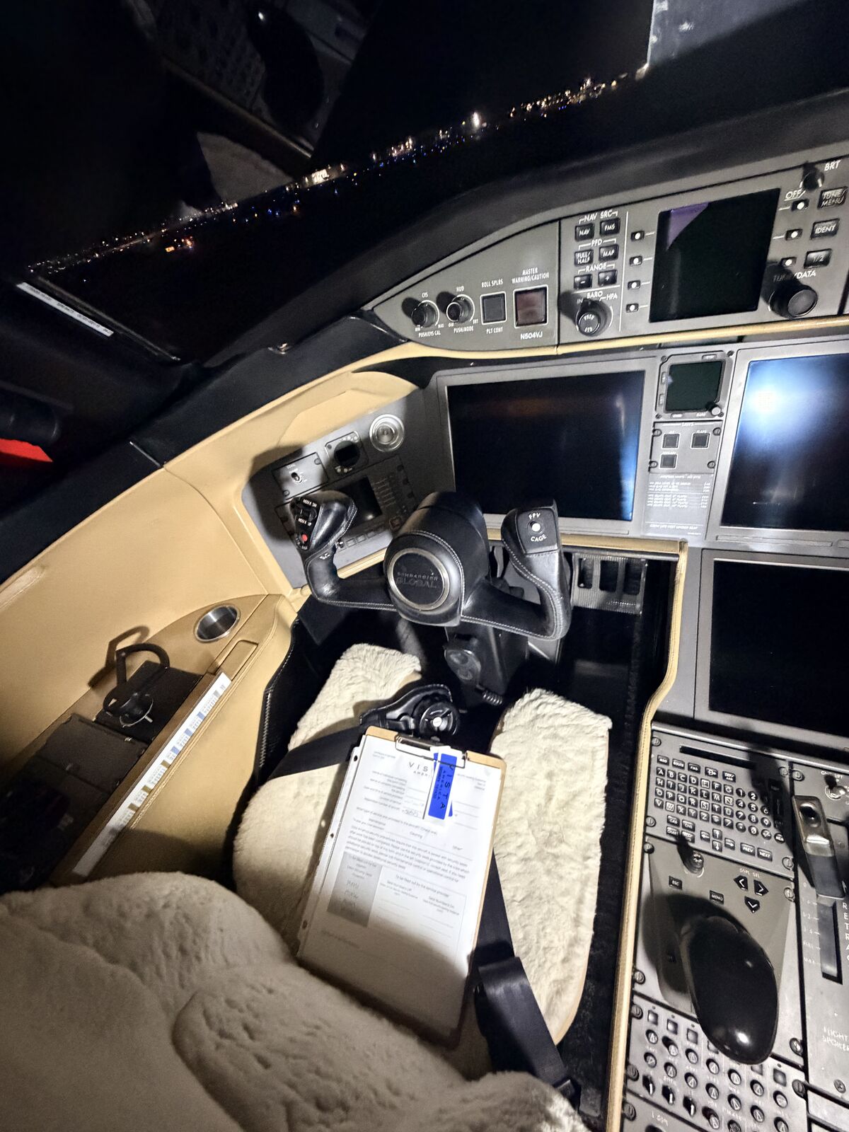 Cessna Citation Excel captain side cockpit with sidestick, avionics panel, and sheepskin seat cover after interior detailing