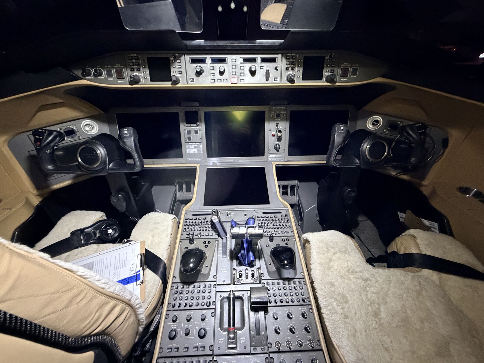 Cessna Citation Excel cockpit with glass panel displays, center pedestal thrust levers, and sheepskin seat covers after detailing