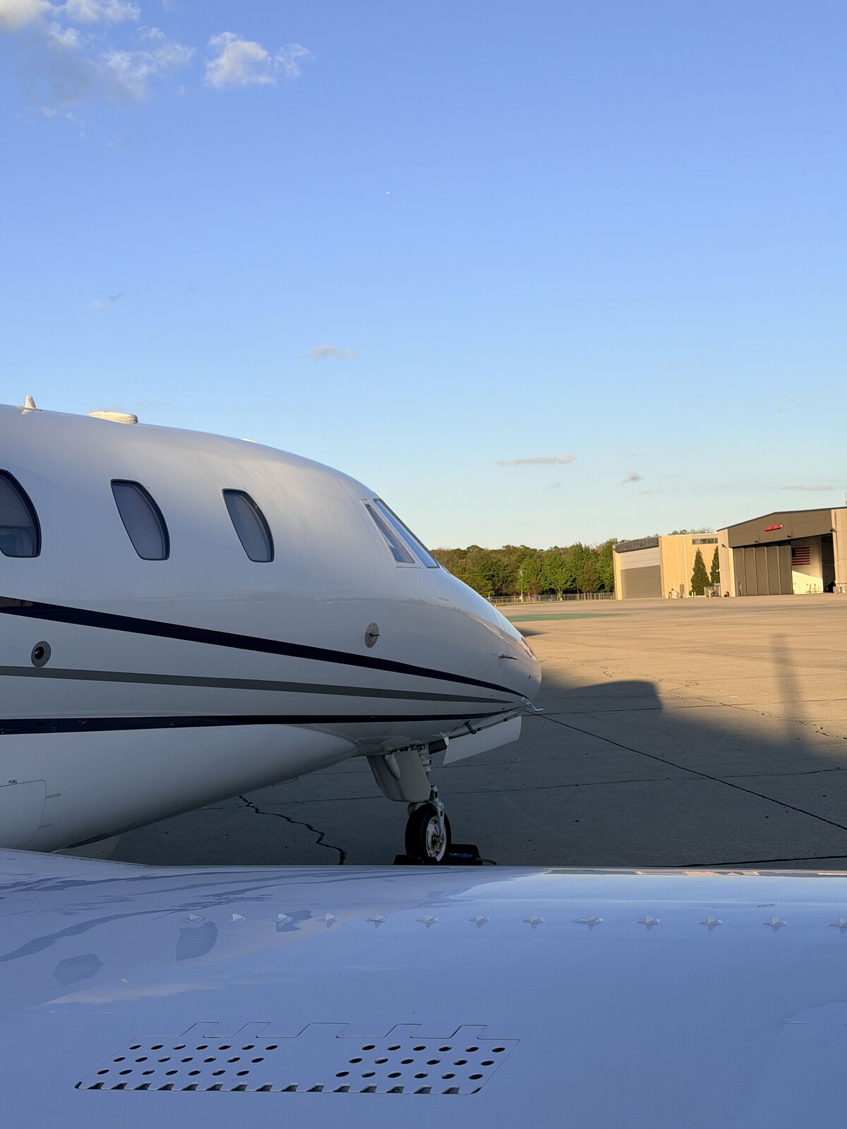 Cessna Citation Excel nose cone and forward fuselage with landing gear on airport ramp after exterior detail