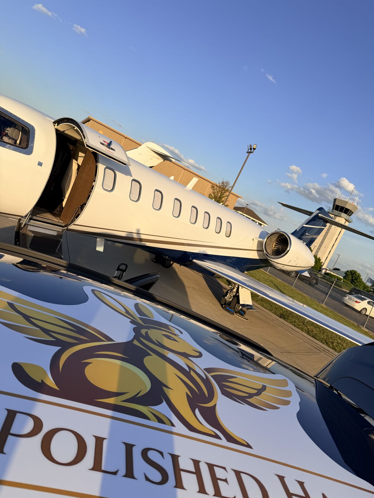 The Polished Hare branded service vehicle parked on ramp next to Cessna Citation Excel showing company logo and aircraft