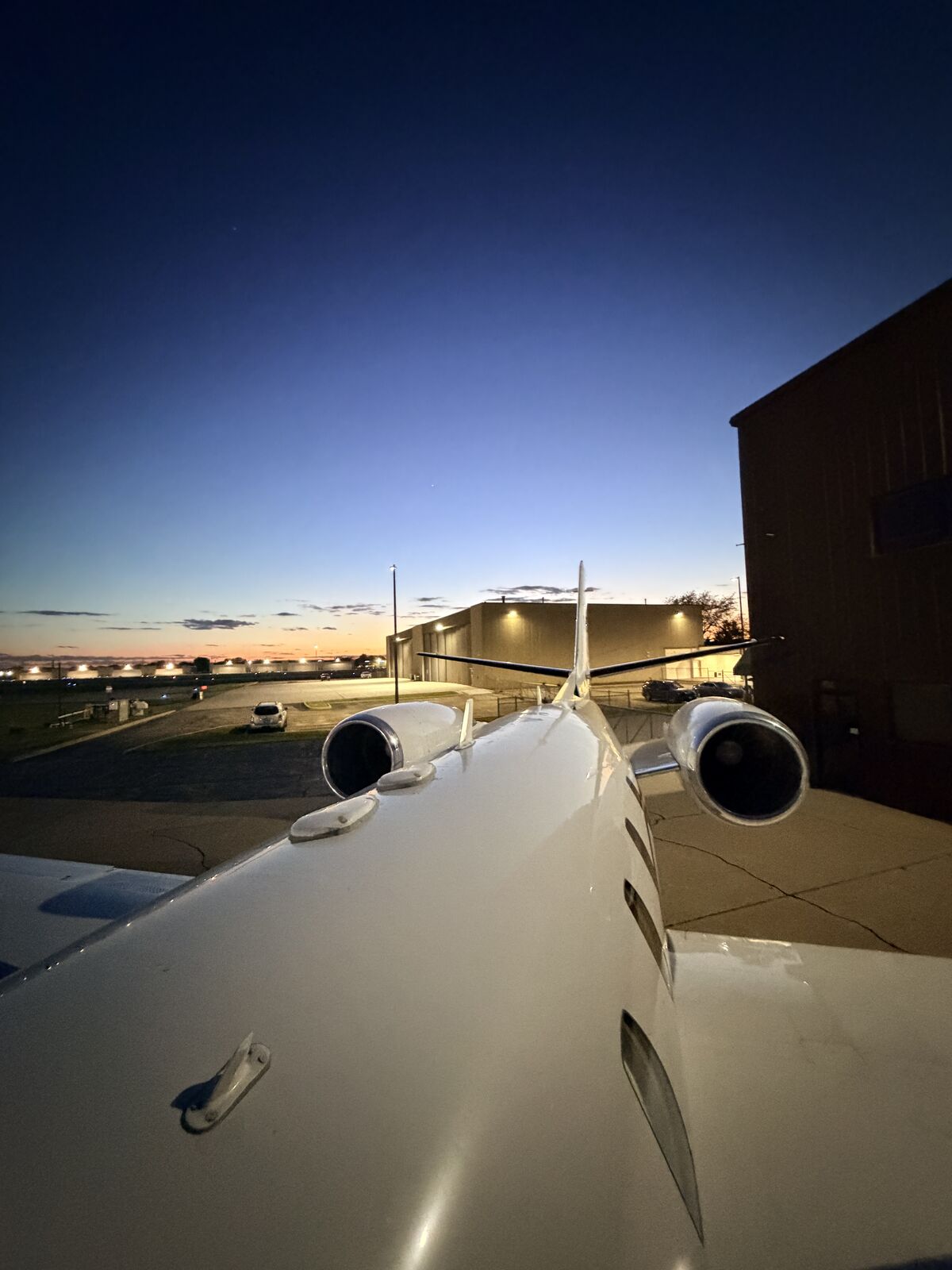 Cessna Citation Excel rear view showing twin engines and T-tail at dusk near hangar after detailing service