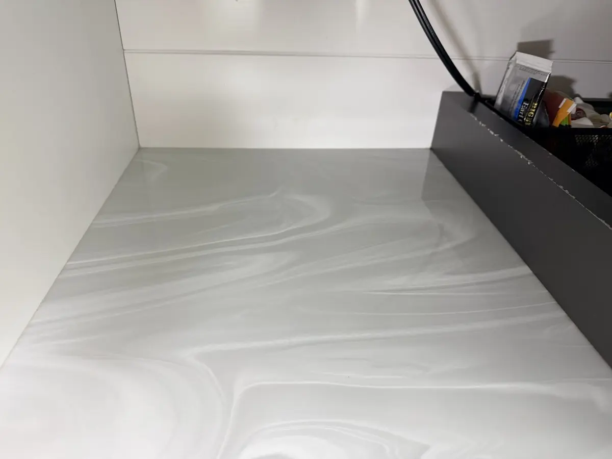 After: Challenger 350 galley counter reset with clean marble-pattern surface and organized provisioning