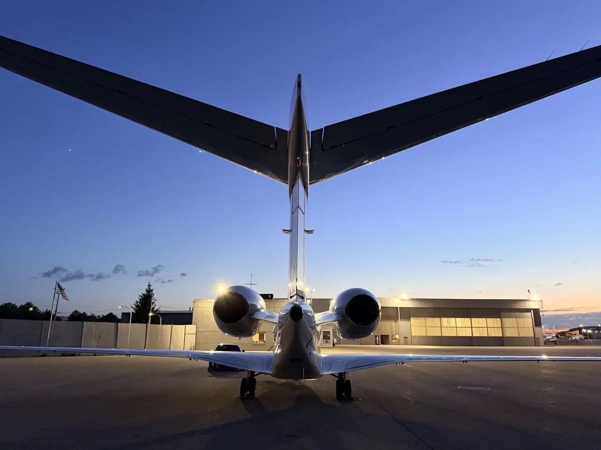 Cessna Citation X photographed head-on from the rear at twilight on the ramp at Kalamazoo KAZO, twin engines and T-tail centered against a blue-hour sky after a Level 2 exterior wash