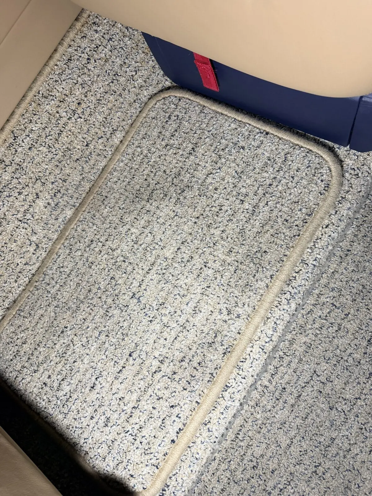 Before: removable carpet panel with use-related buildup in Phenom 300 cabin