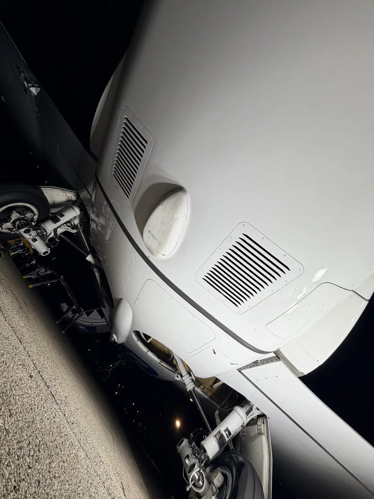 Phenom 300 underbelly and nose gear area showing vents and landing gear after decontamination