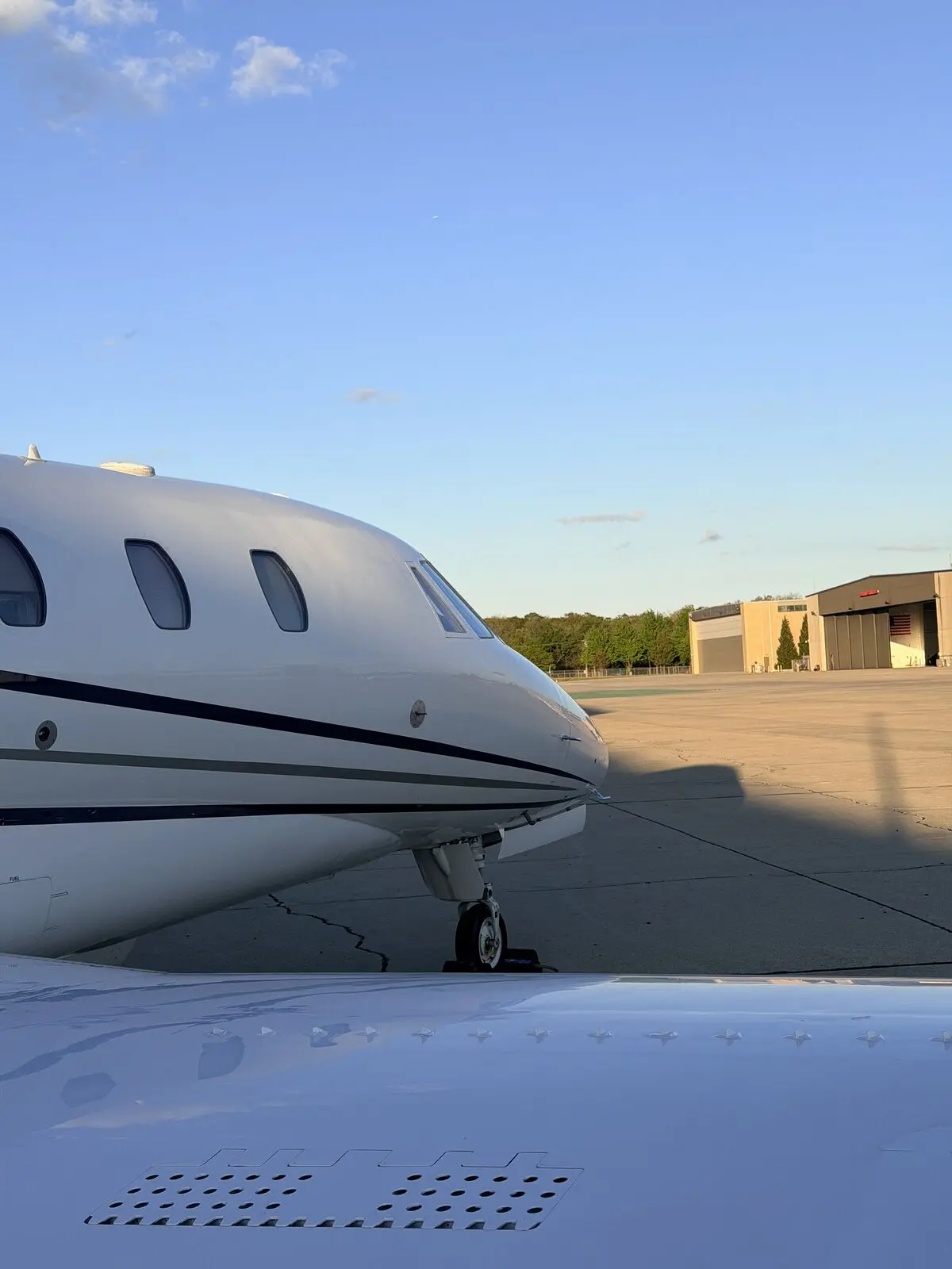 Cessna Citation Excel nose cone and forward fuselage with landing gear on airport ramp after exterior detail