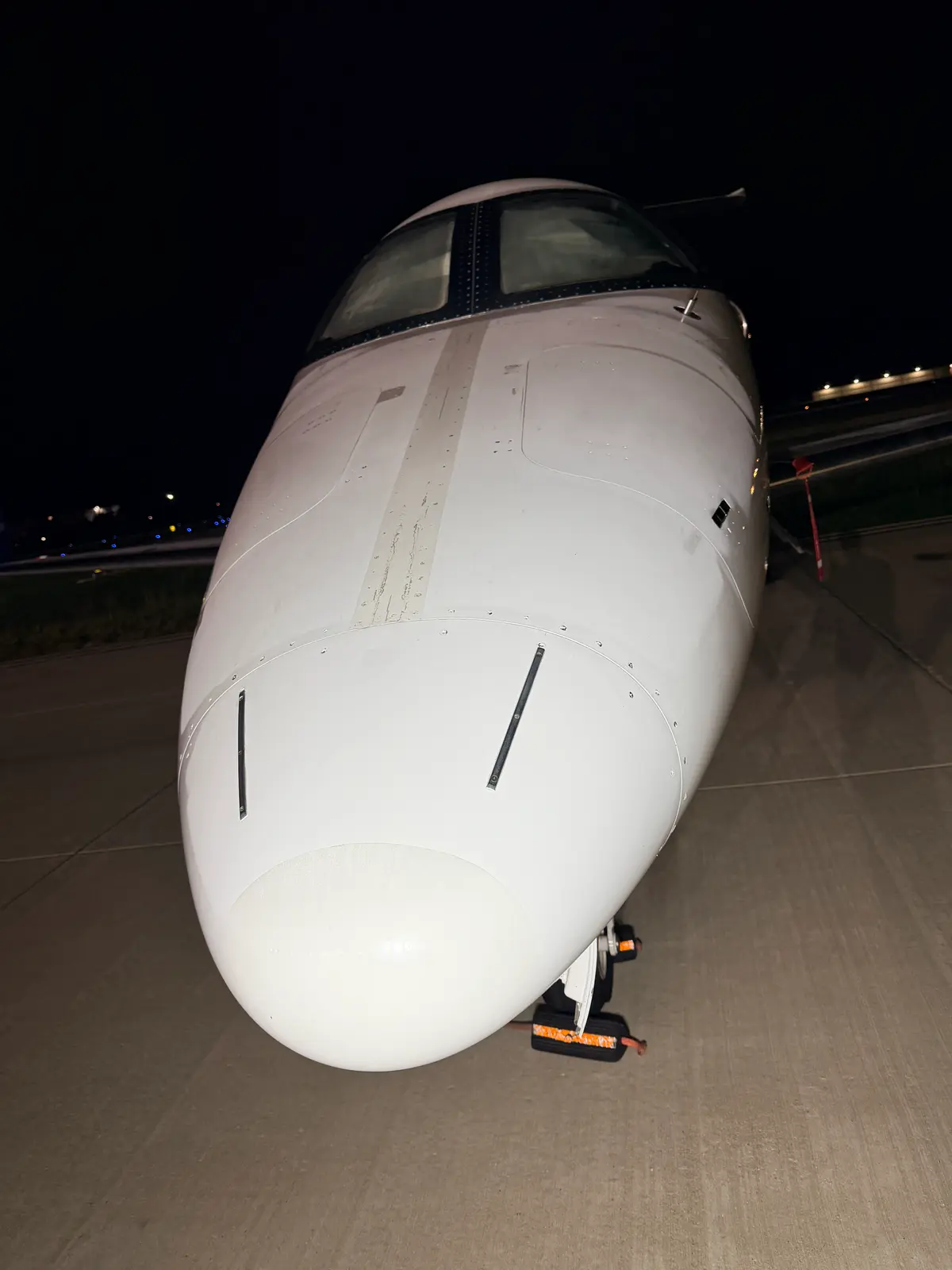 Embraer Phenom 300 glossy blue and white aft fuselage meeting the engine pylon and tail cone at night after detailing