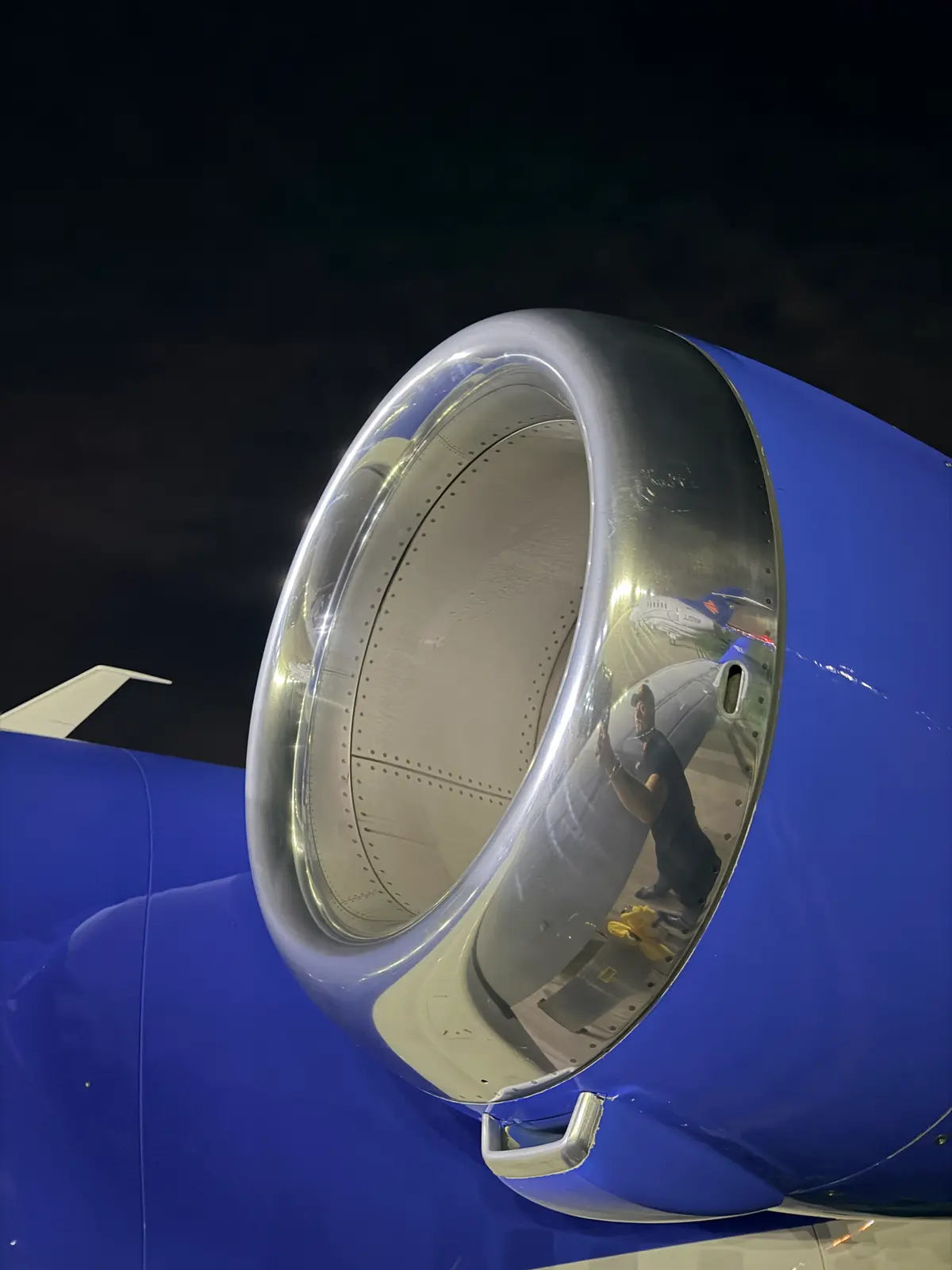 Embraer Phenom 300 underside belly access panel and fasteners detailed near the wing body at night