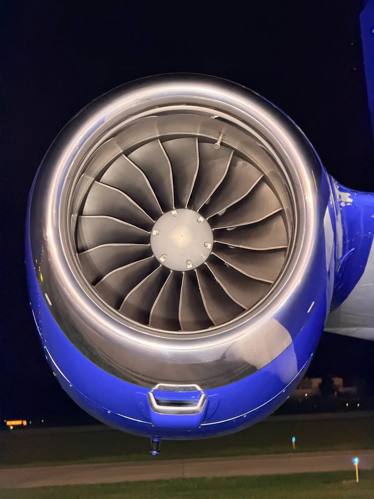 Embraer Phenom 300 engine inlet cowl clean profile with blue nacelle against a black night sky and winglet behind