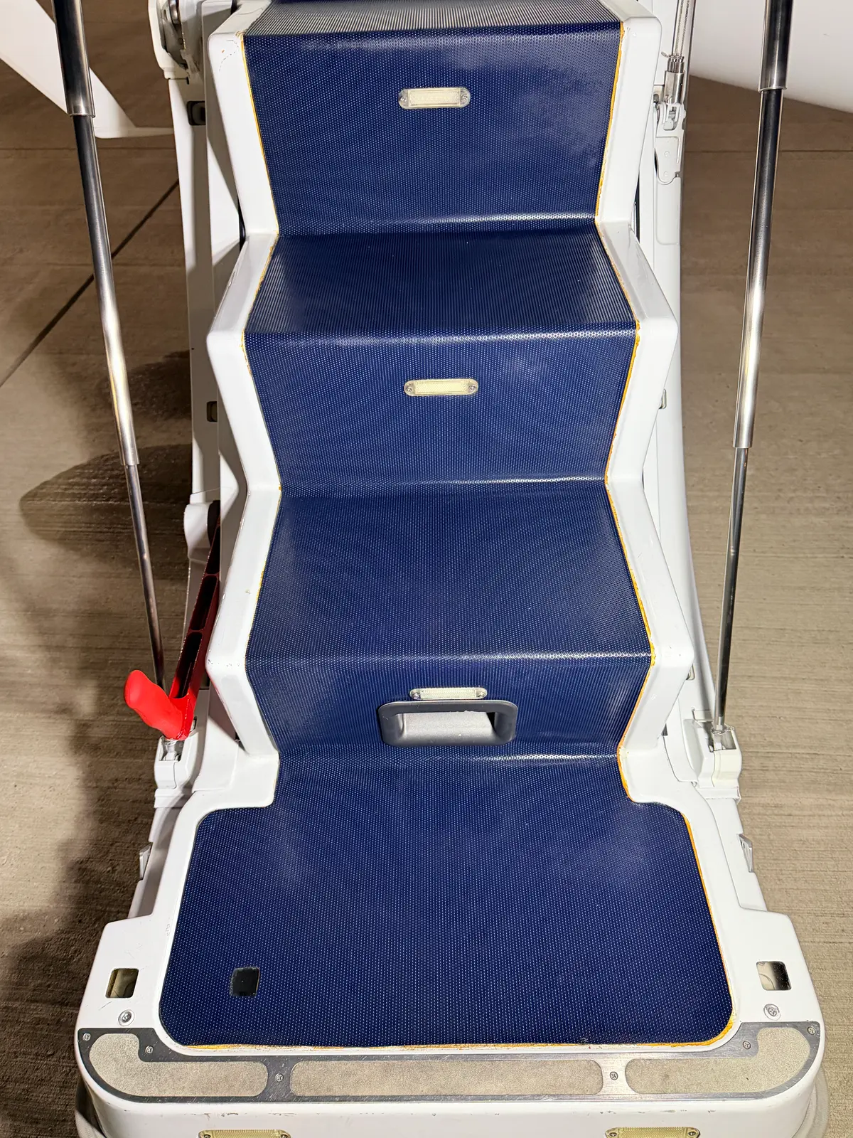 Embraer Phenom 300 over-wing emergency exit hatch with blue textured panel, handle, and red release lever cleaned and detailed