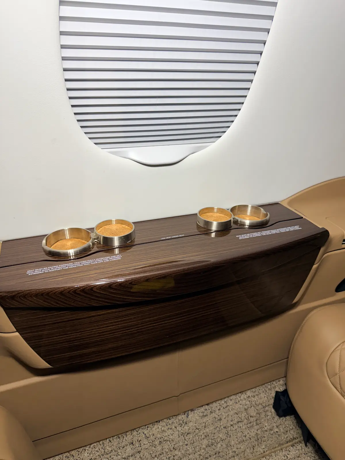 Phenom 300 tan leather seat, armrest, and window surround cleaned with aircraft-aware methods